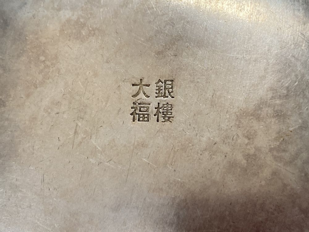 A Chinese white metal concave card case engraved with a dragon, 84mm and a Chinese metal circular box and cover.